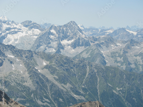 Aerial panoramic view of the Main Caucasus Mountain Ridge from Mount Elbrus, the highest summit in Europe, glacier Seven, incredible blue sky background, impressive nature landscape in North Caucasus