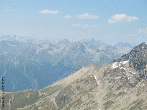 Aerial panoramic view of the Main Caucasus Mountain Ridge from Mount Elbrus, the highest summit in Europe, glacier Seven, incredible blue sky background, impressive nature landscape in North Caucasus