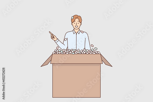 Man climbs out of box and points finger to side, recommending delivery services.
