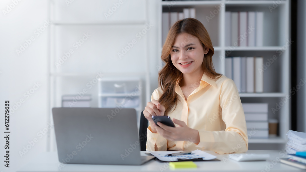 Beautiful smiling businesswoman using a smartphone to work on various application including mobile transaction to send messages, LINE, and various business information sent via social media. Beautiful smiling businesswoman using a smartphone to work on various application including mobile transaction to send messages, LINE, and various business information sent via social media.