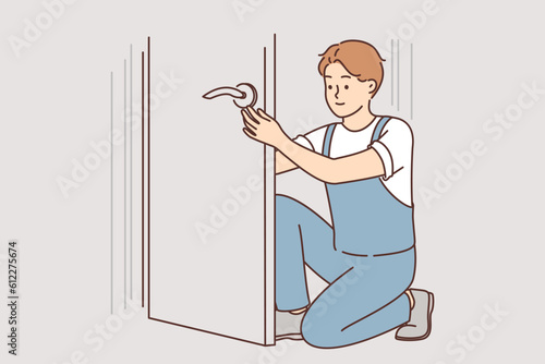 Man repairs door by changing lock to prevent criminals from entering apartment or home