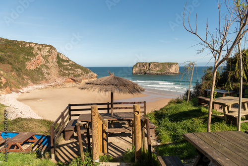 Panoramic view of the golden sandy beach and turquoise water of the tourist town of Andrin beach on the coast of Asturias on a sunny summer day