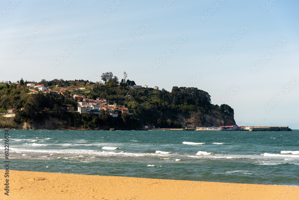 Panoramic view of the Greek beach on the touristic coast of Asturias at high tide with calm sea and golden sand on a sunny day with blue skies