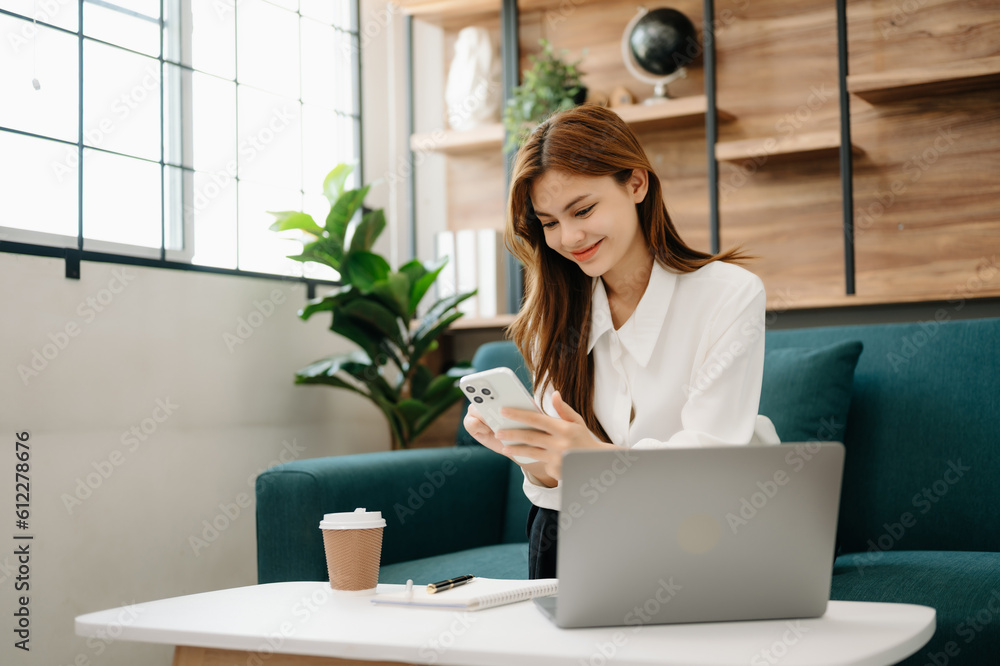 Young beautiful woman using laptop and tablet while sitting at her working place. Concentrated at work. in living room on the sofa at home office. Young beautiful woman using laptop and tablet while sitting at her working place. Concentrated at work. in living room on the sofa at home office.