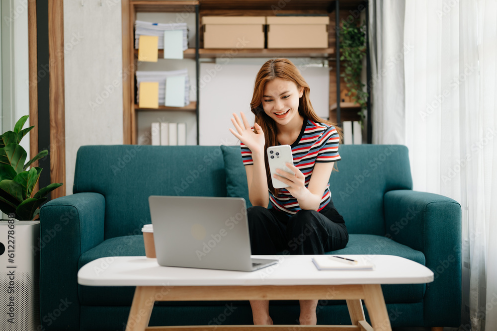 Young beautiful woman using laptop and tablet while sitting at her working place. Concentrated at work. in living room on the sofa at home office. Young beautiful woman using laptop and tablet while sitting at her working place. Concentrated at work. in living room on the sofa at home office.