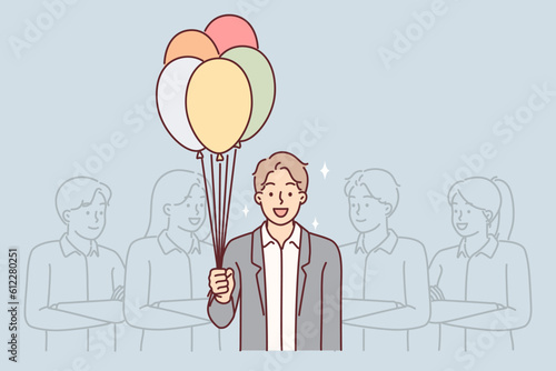 Business man with balloons stands near colleagues congratulating boss on birthday