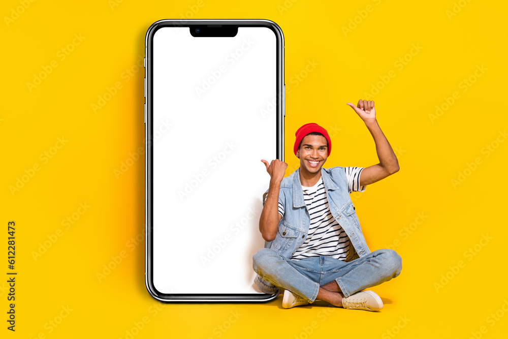 Full length photo of cute excited man wear jeans outfit typing thumbs device empty space isolated yellow color background Full length photo of cute excited man wear jeans outfit typing thumbs device empty space isolated yellow color background