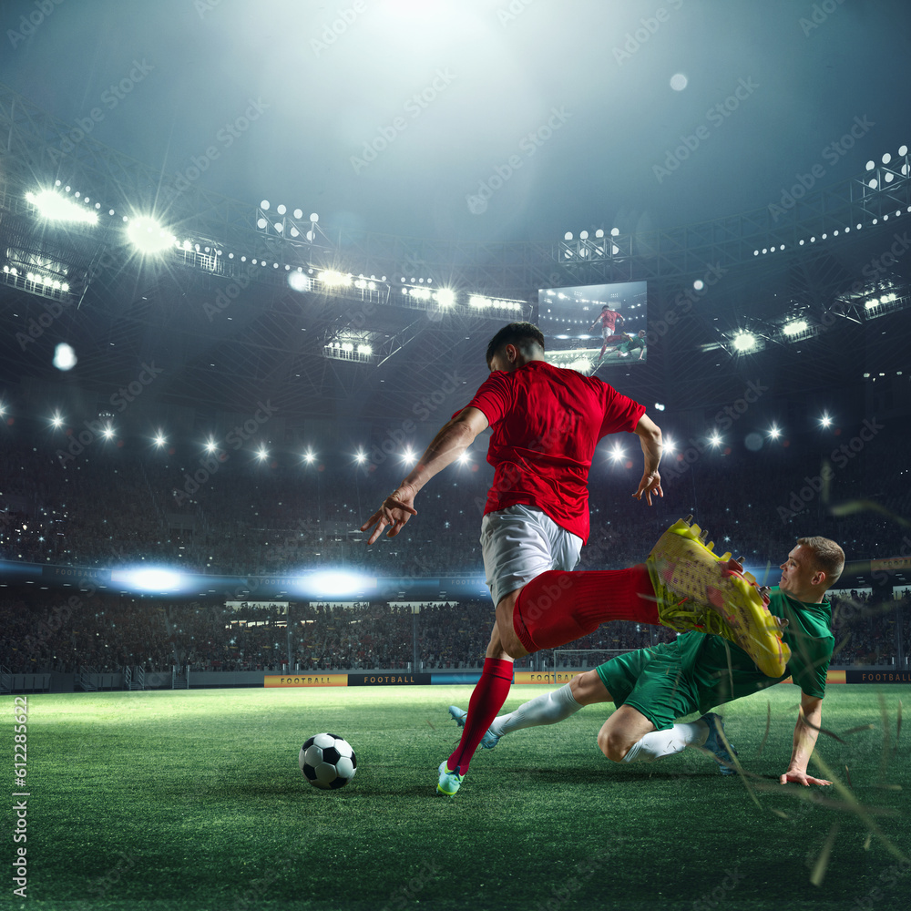 Naklejka premium Live match. Football players in uniform during game, playing at 3D stadium with flashlights and blurred audience on background. Concept of professional sport, championship, game, achievement