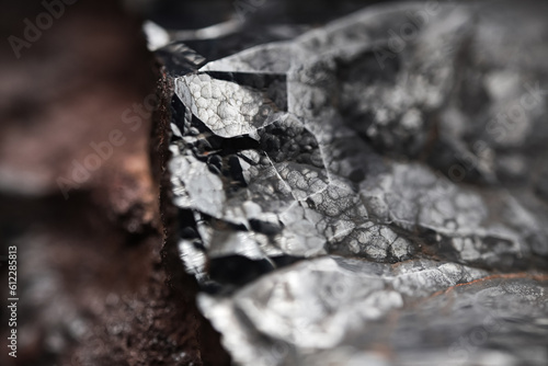 Metal rock texture. Close up of a raw hematite stone. Shiny mineral with an abstract pattern. 