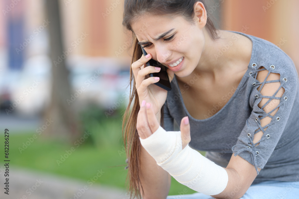Convalescent woman with bandaged arm calling on phone Convalescent woman with bandaged arm calling on phone