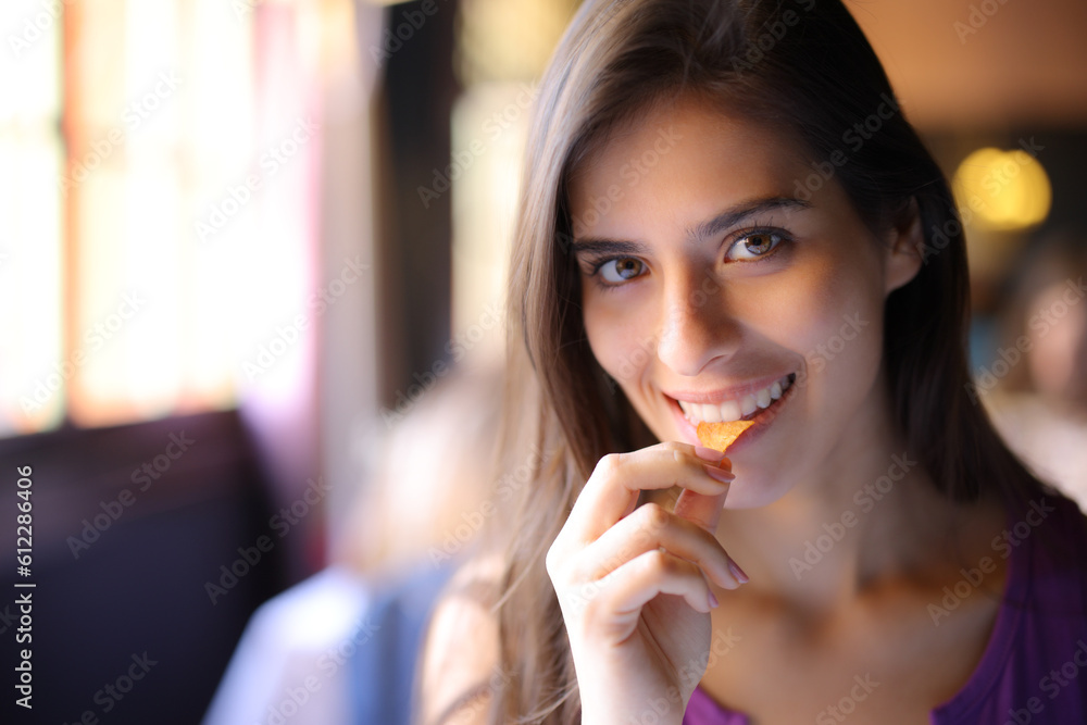 Happy woman in a restaurant eating and looking at you Happy woman in a restaurant eating and looking at you