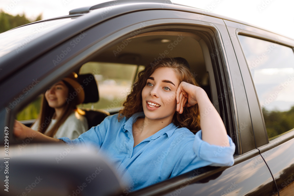 Two young women on car trip having fun. Lifestyle, travel, tourism, nature, active life.