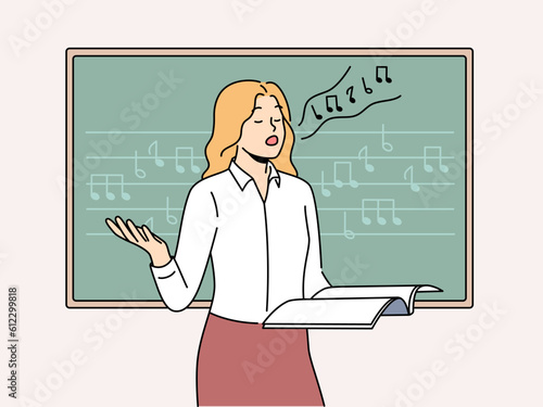 Woman vocalist sings standing near blackboard with notes and helping students develop voice. Girl holds magazine and sings wanting to become professional vocalist or audio composer