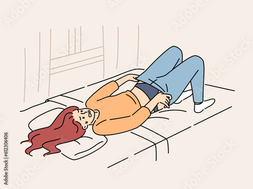 Overweight woman tries in vain to put on small pants lying on bed in bedroom of apartment. Overweight young girl needs help of nutritionist or fitness trainer to reduce waist and hips