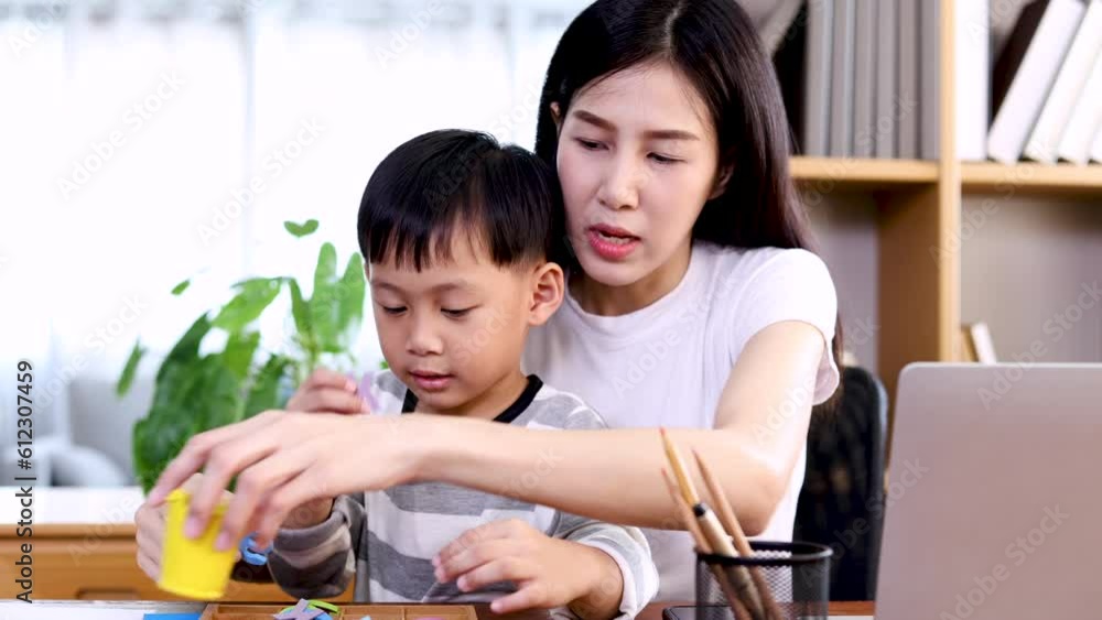 Multitasking Asian mother playing with cheerful kid while working at home, lifestyle motherhood happy nurturing son spend time teaching drawing together with love and tenderness, lifestyle working mom Multitasking Asian mother playing with cheerful kid while working at home, lifestyle motherhood happy nurturing son spend time teaching drawing together with love and tenderness, lifestyle working mom