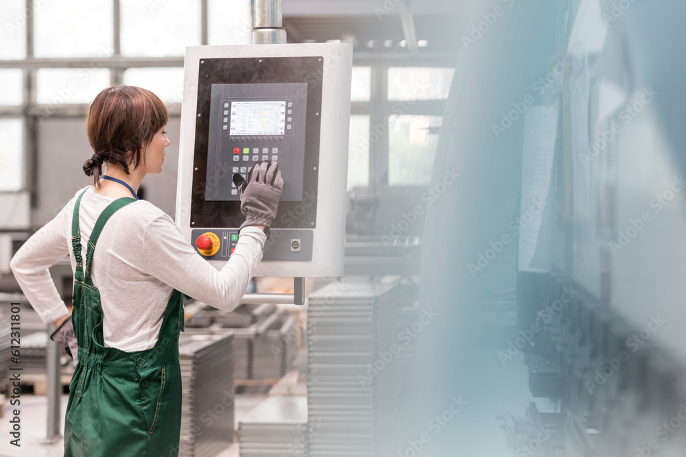 Worker at control panel operating machinery in factory Worker at control panel operating machinery in factory
