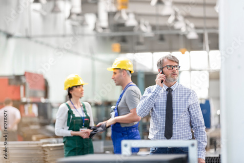 Businessman and workers in factory