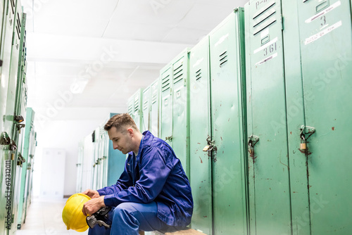 Tablou pe pânză Worker holding hard-hat in locker room