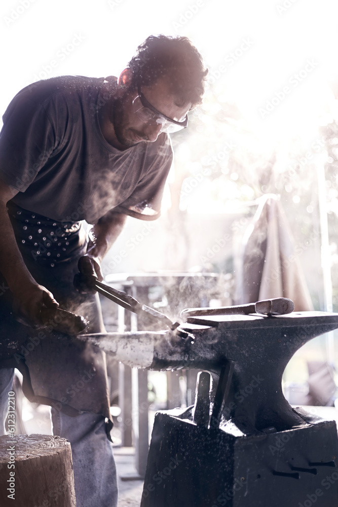 Blacksmith shaping iron over anvil in forge Blacksmith shaping iron over anvil in forge