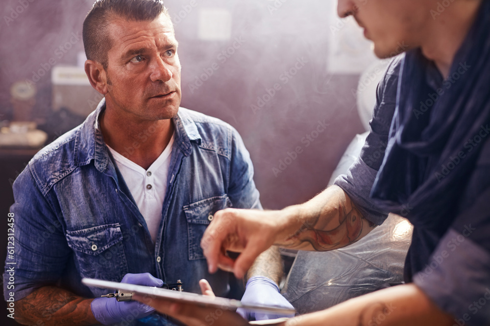 Man with digital tablet talking to tattoo artist Man with digital tablet talking to tattoo artist