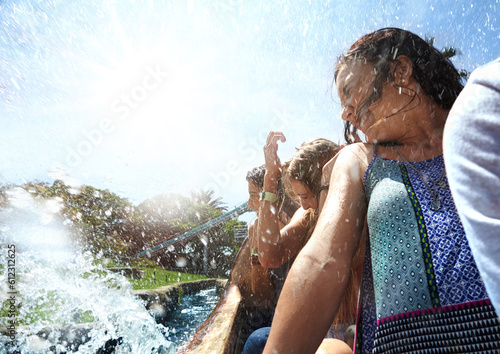 Fotografi Young women getting splashed on water park ride