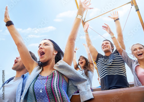 Friends cheering and riding amusement park ride
