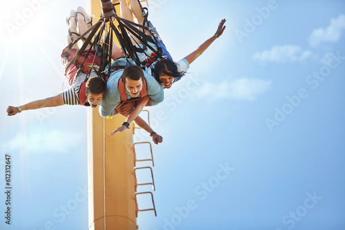 Friends bungee jumping at amusement park