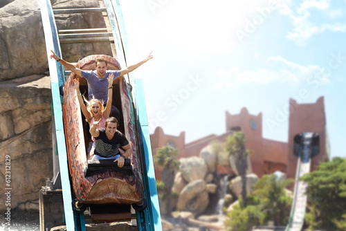 Tableau sur toile Enthusiastic friends cheering and riding log amusement park ride