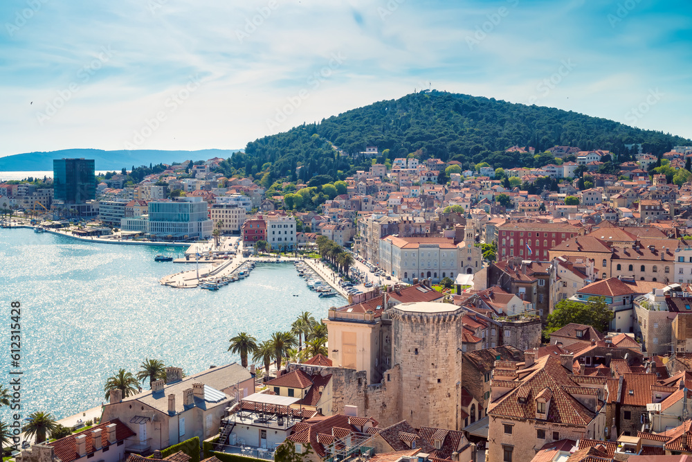 Aerial panoramic view of the promenade of picturesque town of Split with the red roofs of old town houses, historical buildings and boats lined up on the pier, Croatia..