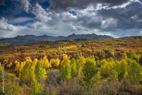 Clouds over yellow autumn trees in valley below mountains  Dallas Divide  Colorado  United States  