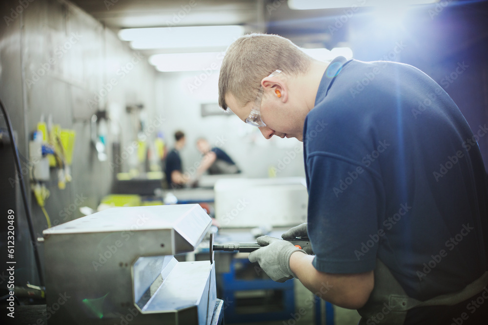 Worker using machinery in steel factory