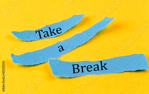 TAKE A BREAK text on a blue pieces of paper on yellow background, business concept #612321254