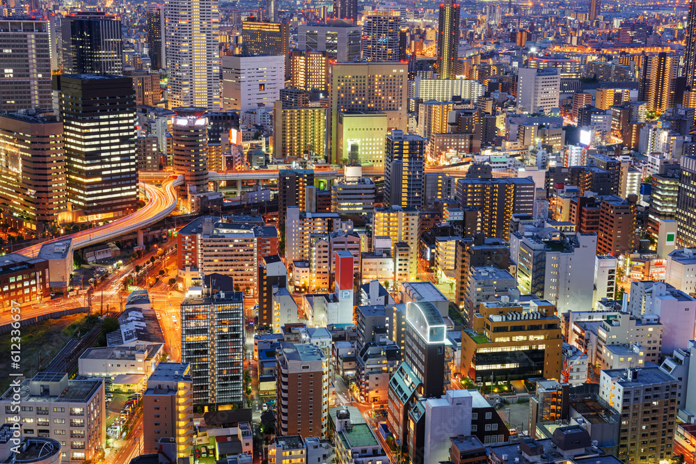 Osaka, Japan cityscape with dense architecture in the Umeda District at night.