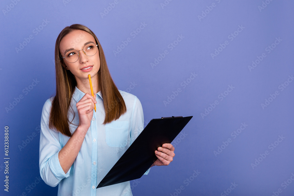 Portrait of charming pensive minded lady broker agent isolated on blue color background Portrait of charming pensive minded lady broker agent isolated on blue color background