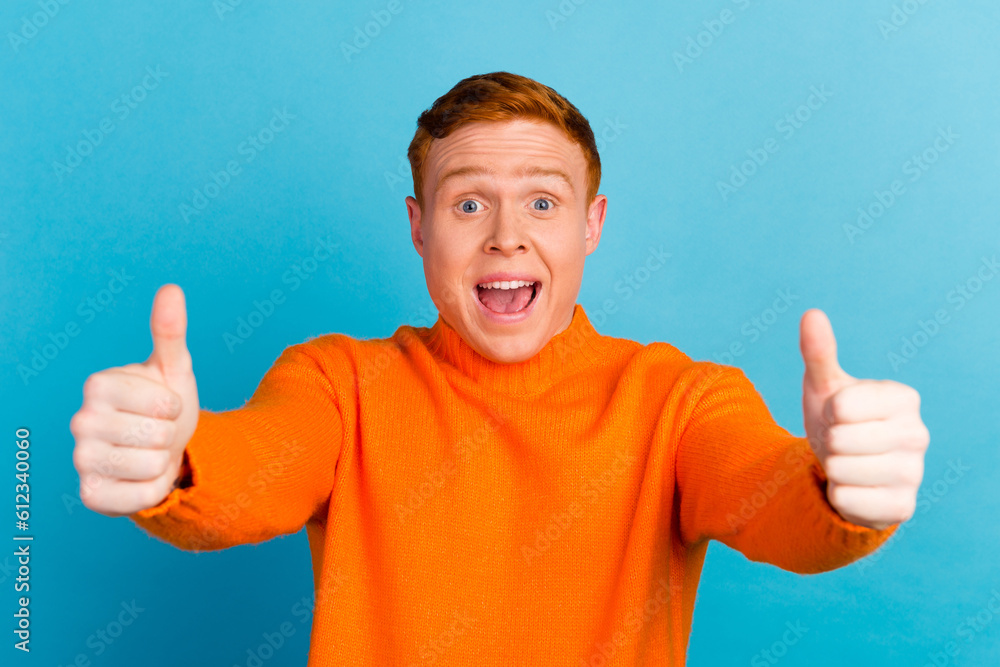 Handsome excited man smiling and giving thumbs up on blue isolated background Handsome excited man smiling and giving thumbs up on blue isolated background