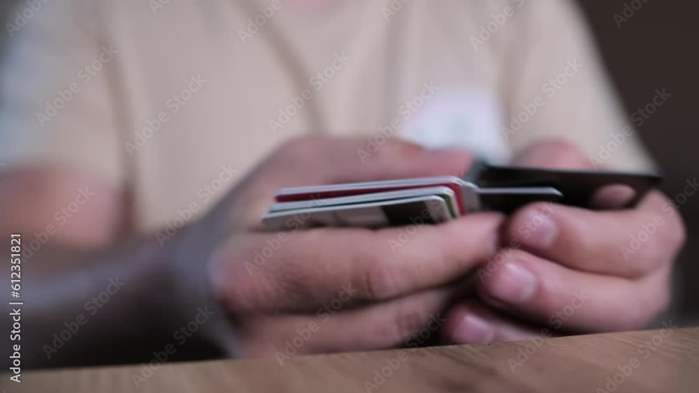 Close up, man hands go through pile cards of different banks. Financial services, payment methods, and the economy. Close up, man hands go through pile cards of different banks. Financial services, payment methods, and the economy.
