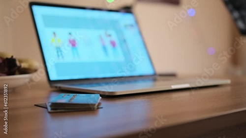 Open laptop lies on wooden desktop next to a stack of bank cards, close up. Efficient money management. Work from home. photo