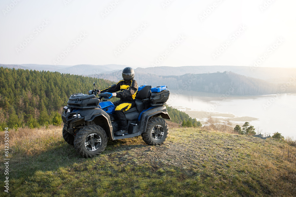 ATV with driver on top of mountain. Offroad travel adventure trip expedition. Extreme recreation activity on an ATV. ATV with driver on top of mountain. Offroad travel adventure trip expedition. Extreme recreation activity on an ATV.