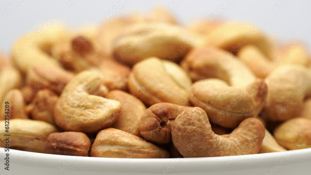 Cashew Pieces on a turntable from overhead. Plant based ingredient. Dried cashew nuts. Macro shot. Raw snack. Pile cashew nuts without shell, rotates, close up. Whole nut kernels. Rotation Cashew Pieces on a turntable from overhead. Plant based ingredient. Dried cashew nuts. Macro shot. Raw snack. Pile cashew nuts without shell, rotates, close up. Whole nut kernels. Rotation