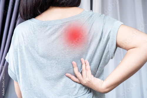 Woman suffering from Scapulocostal Syndrome Back and Shoulder Muscle Pain photo