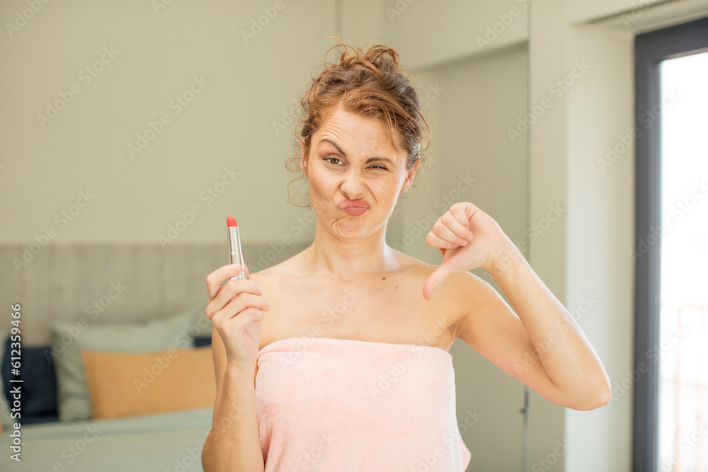 young pretty woman feeling cross,showing thumbs down. lipstick concept young pretty woman feeling cross,showing thumbs down. lipstick concept