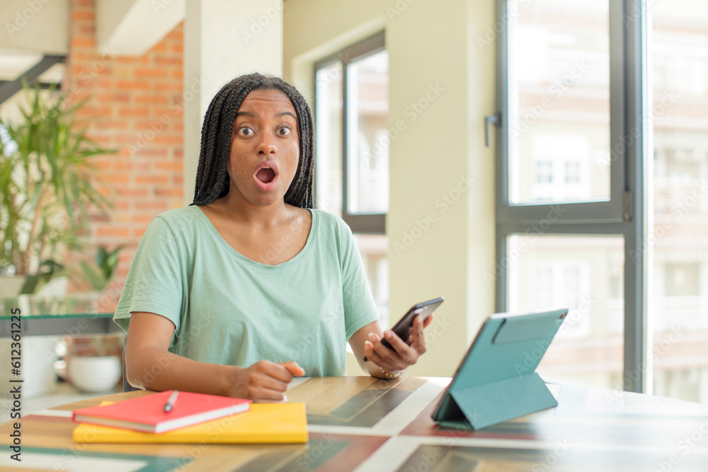black afro woman feeling extremely shocked and surprised. studying concept black afro woman feeling extremely shocked and surprised. studying concept
