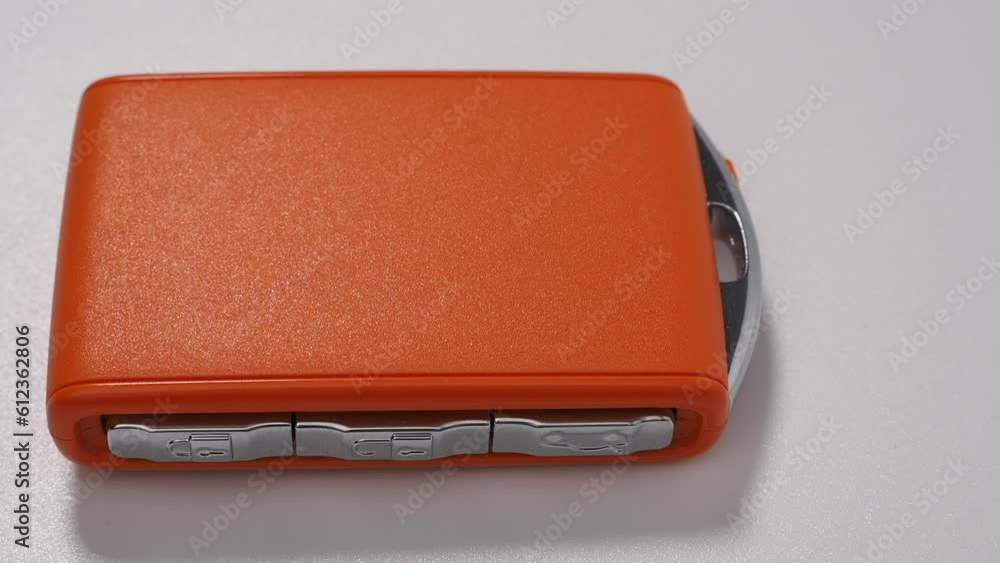 Modern wireless orange car ignition key on a white background. Wireless key to start the engine. Modern car keys. Modern wireless orange car ignition key on a white background. Wireless key to start the engine. Modern car keys.