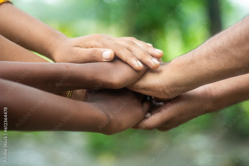 Many hands are placed together on top of each other and the background blur Many hands are placed together on top of each other and the background blur