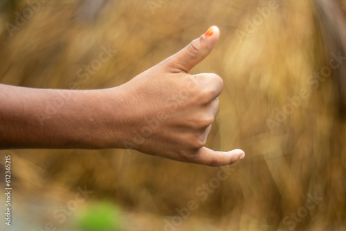 A man shows two fingers of his hand and the background is blurred © Rokonuzzamnan