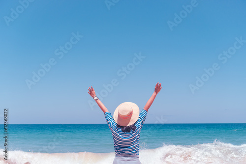 Canvas Print Young woman rise hand up to sky feel relax and free with summer beach background