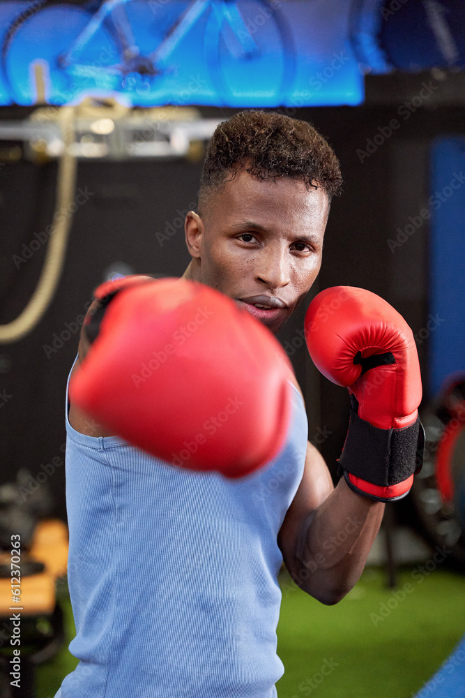 Powerful Black Male Boxer Throwing a Punch with Gloves, Demonstrating Strength and Skill in the Ring