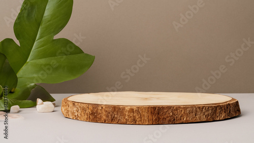 Fototapeta Naklejka Na Ścianę i Meble -  A wooden product display podium with green leaves and stones on a tan background.