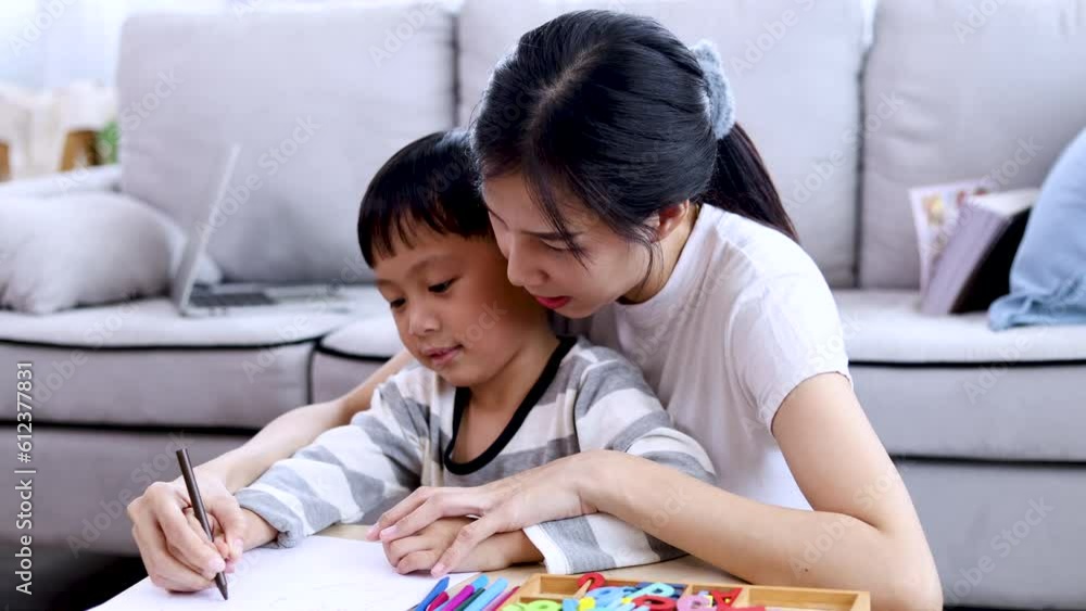 Asian mother spend time together with kids teaching drawing colorful paper, holiday lifestyle motherhood love and tenderness with son concept, cheerful happy adorable boy playing with mom at home Asian mother spend time together with kids teaching drawing colorful paper, holiday lifestyle motherhood love and tenderness with son concept, cheerful happy adorable boy playing with mom at home