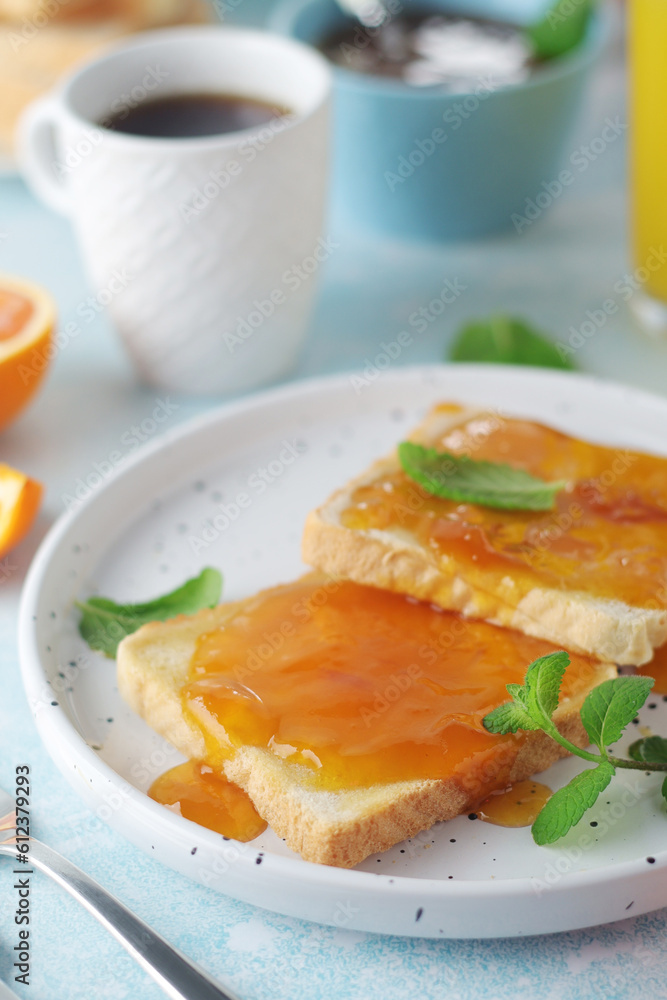 Sandwiches with marmalade, orange juice and coffee ready for breakfast Sandwiches with marmalade, orange juice and coffee ready for breakfast